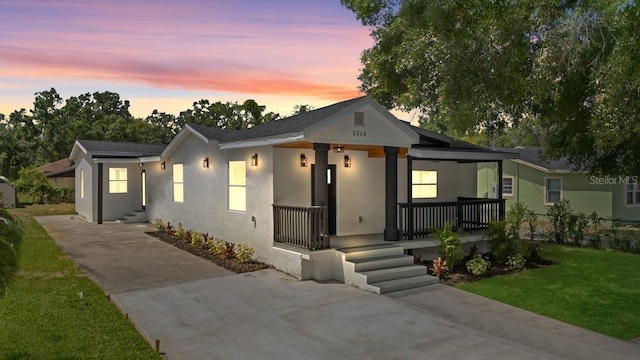3215 E Powhatan Ave, Tampa, FL 33610 - bungalow-style house with driveway, a porch, and stucco siding