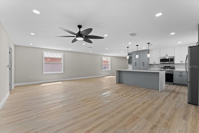 3215 E Powhatan Ave, Tampa, FL 33610 - kitchen featuring appliances with stainless steel finishes, open floor plan, baseboards, recessed lighting, and a center island