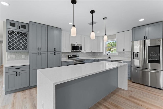 3215 E Powhatan Ave, Tampa, FL 33610 - kitchen with stainless steel appliances, light countertops, light wood-style flooring, tasteful backsplash, and recessed lighting