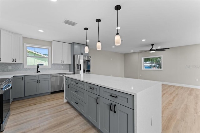 3215 E Powhatan Ave, Tampa, FL 33610 - kitchen with stainless steel appliances, gray cabinetry, a sink, backsplash, and recessed lighting
