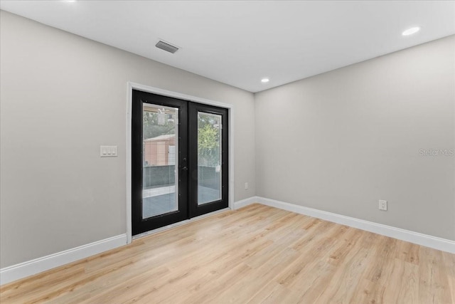 3215 E Powhatan Ave, Tampa, FL 33610 - empty room featuring french doors, wood finished floors, baseboards, and recessed lighting