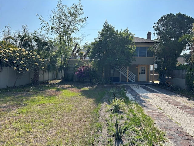 view of yard with stairway and a fenced backyard