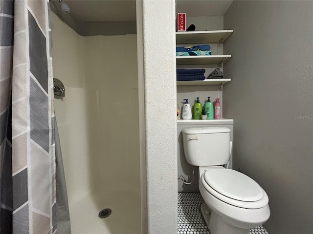 full bath featuring tile patterned floors, toilet, and a stall shower