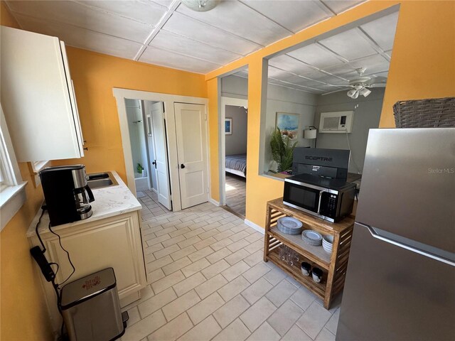 kitchen with ceiling fan, appliances with stainless steel finishes, and light tile patterned flooring
