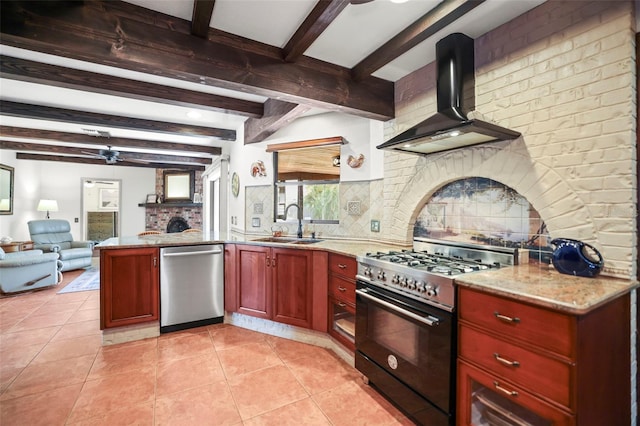 kitchen featuring appliances with stainless steel finishes, wall chimney exhaust hood, ceiling fan, reddish brown cabinets, and a sink