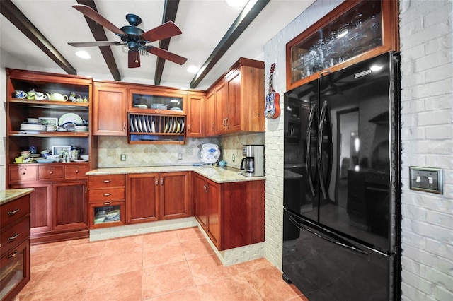 kitchen with freestanding refrigerator, beamed ceiling, backsplash, a ceiling fan, and light stone counters
