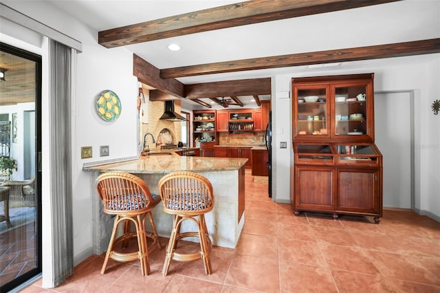 indoor wet bar featuring beam ceiling, light tile patterned floors, wall chimney range hood, backsplash, and recessed lighting