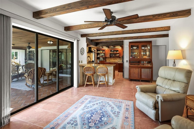 living area featuring a ceiling fan, beamed ceiling, and light tile patterned floors
