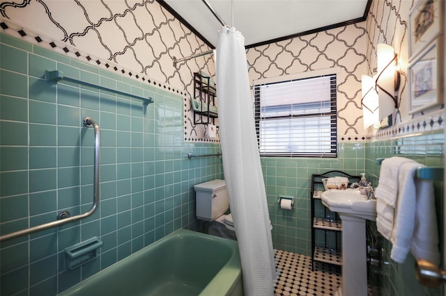bathroom featuring wallpapered walls, tile walls, shower / bath combination with curtain, and wainscoting