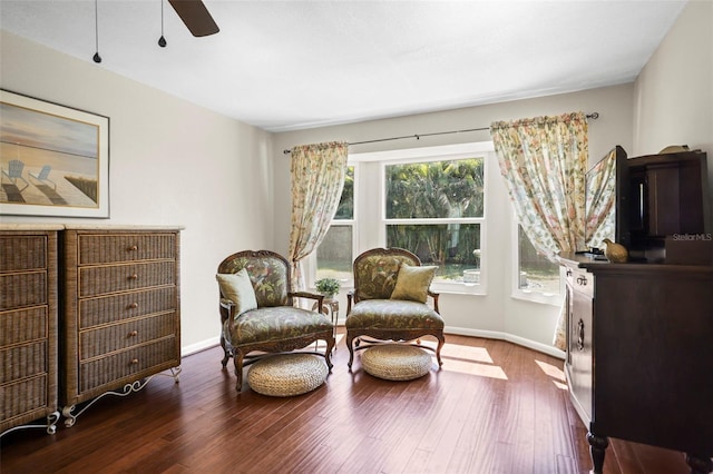 sitting room featuring a ceiling fan, baseboards, and wood finished floors