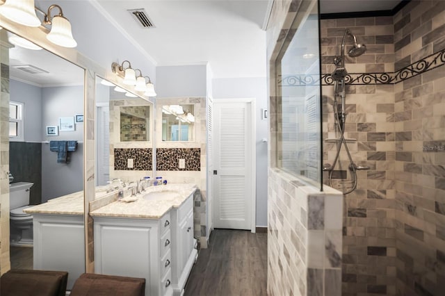 bathroom with walk in shower, wood finished floors, toilet, vanity, and crown molding