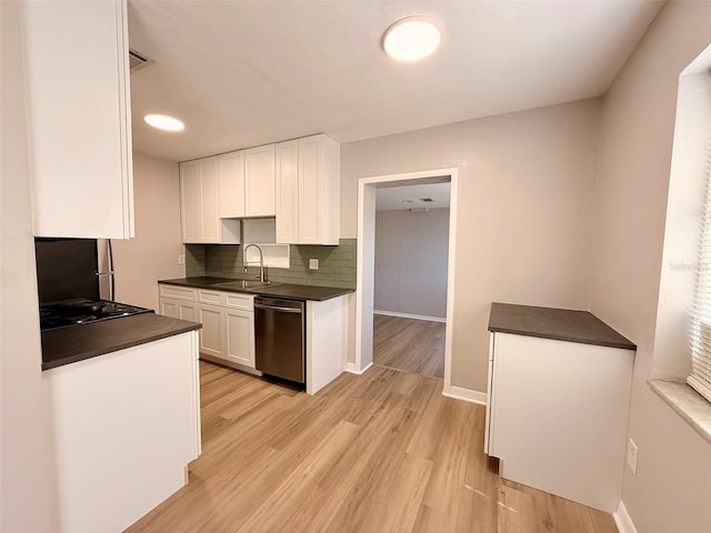 2201 Flamingo Ave, Deltona, FL 32738 - kitchen with stainless steel dishwasher, dark countertops, a sink, and white cabinetry