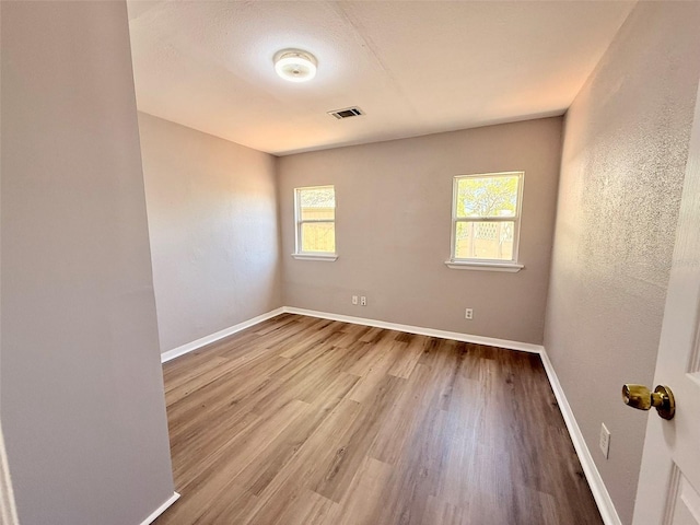 2201 Flamingo Ave, Deltona, FL 32738 - unfurnished room featuring plenty of natural light, wood finished floors, and baseboards
