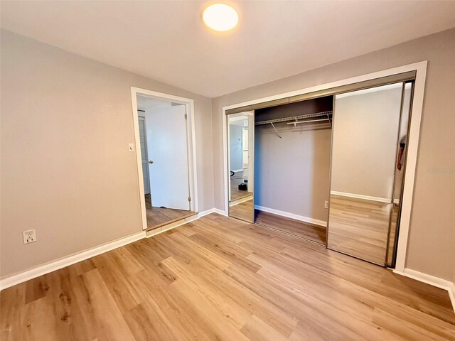 2201 Flamingo Ave, Deltona, FL 32738 - unfurnished bedroom featuring a closet, light wood-type flooring, and baseboards