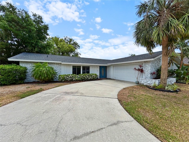 single story home with concrete driveway, stone siding, and a garage