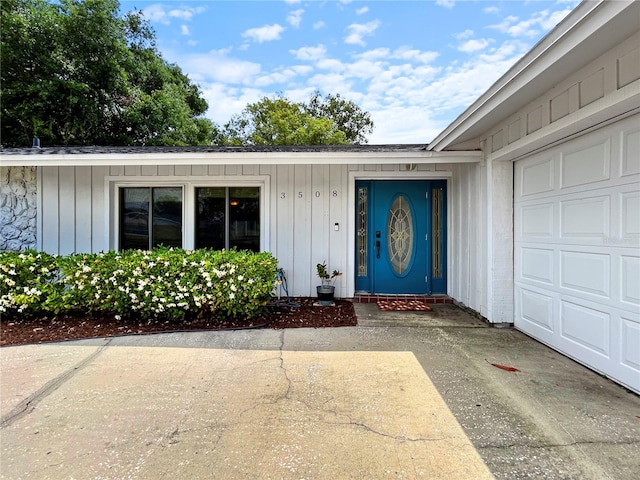 entrance to property with board and batten siding and a garage