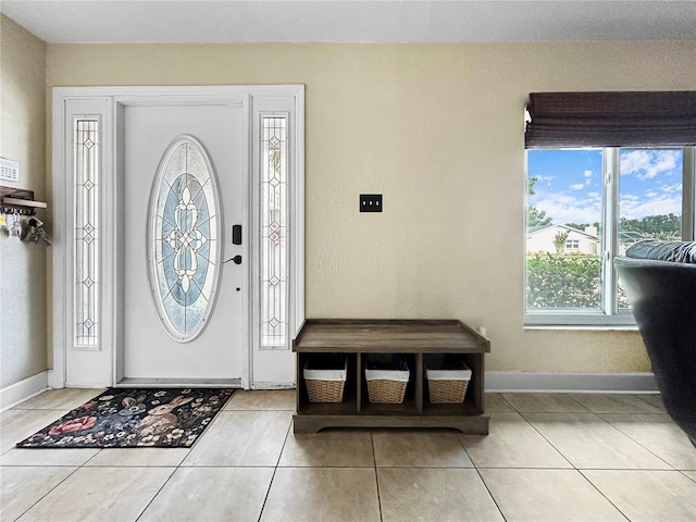 tiled entrance foyer with baseboards and plenty of natural light
