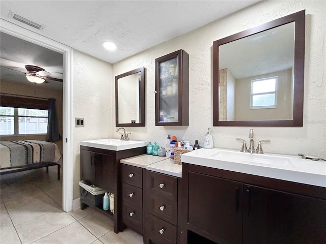 full bath featuring tile patterned flooring, visible vents, a sink, and a textured wall