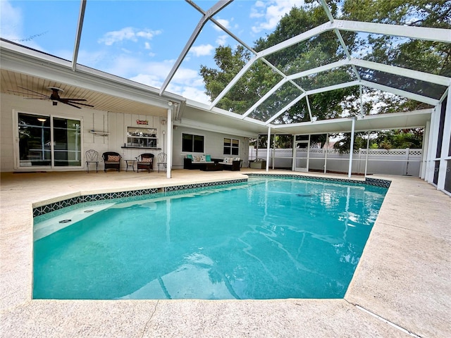outdoor pool with ceiling fan, a patio area, an outdoor living space, and a lanai