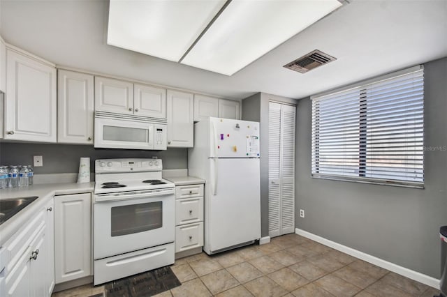 kitchen featuring white cabinets, visible vents, baseboards, white appliances, and light countertops