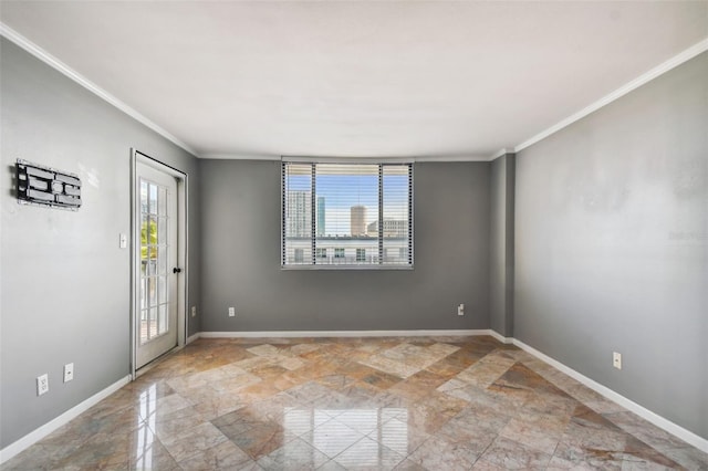 unfurnished room featuring ornamental molding, baseboards, and stone finish floor