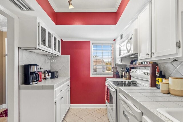 3823 N Oak Dr Unit K22, Tampa, FL 33611 - kitchen featuring white cabinetry, tile counters, white appliances, and tasteful backsplash