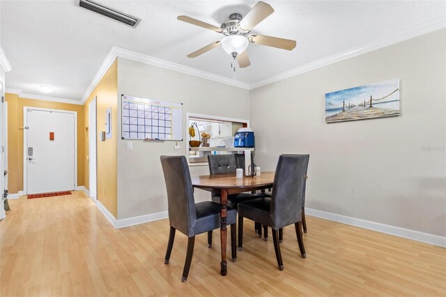 3823 N Oak Dr Unit K22, Tampa, FL 33611 - dining area with visible vents, light wood finished floors, crown molding, a ceiling fan, and baseboards