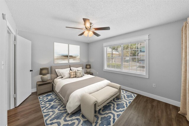 bedroom with wood finished floors, baseboards, a textured ceiling, and ceiling fan