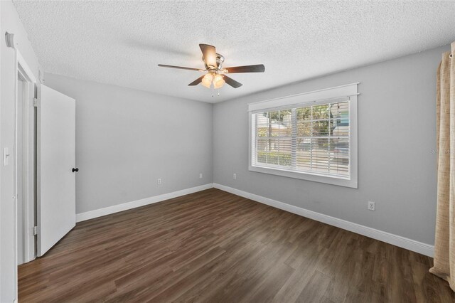 unfurnished bedroom featuring dark wood finished floors, baseboards, a textured ceiling, and a ceiling fan