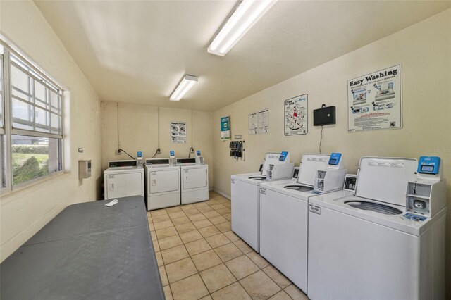 communal laundry room featuring washing machine and dryer and light tile patterned flooring