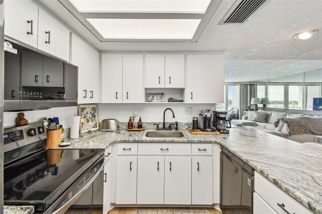 500 Treasure Island Cswy Unit 607, Treasure Island, FL 33706 - kitchen with stainless steel electric range oven, a sink, and white cabinets