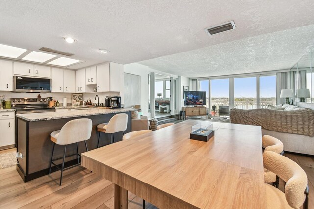 500 Treasure Island Cswy Unit 607, Treasure Island, FL 33706 - dining area with a textured ceiling and light wood-style flooring