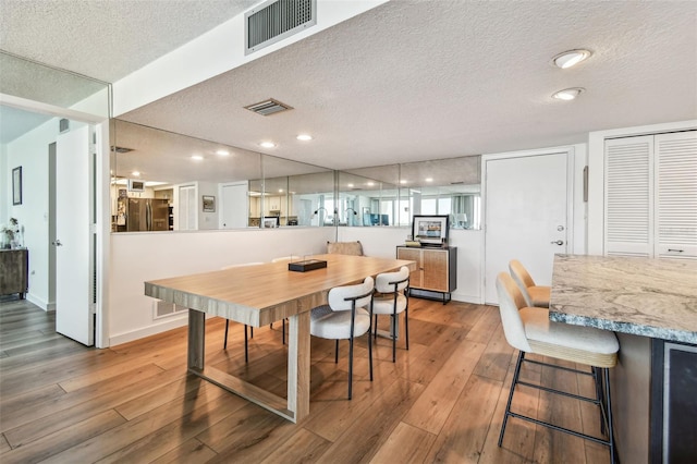 500 Treasure Island Cswy Unit 607, Treasure Island, FL 33706 - dining room featuring a textured ceiling, hardwood / wood-style floors, baseboards, and recessed lighting