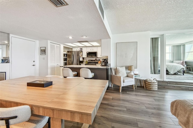 500 Treasure Island Cswy Unit 607, Treasure Island, FL 33706 - dining space with a textured ceiling and dark wood-style flooring