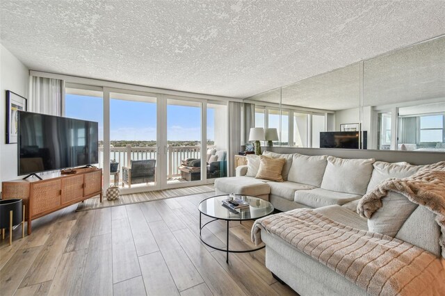 500 Treasure Island Cswy Unit 607, Treasure Island, FL 33706 - living area featuring a textured ceiling, a wall of windows, and wood finished floors