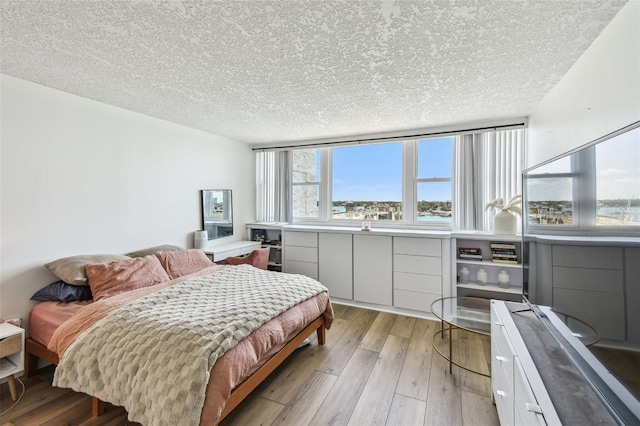 500 Treasure Island Cswy Unit 607, Treasure Island, FL 33706 - bedroom with multiple windows, light wood-style floors, and a textured ceiling