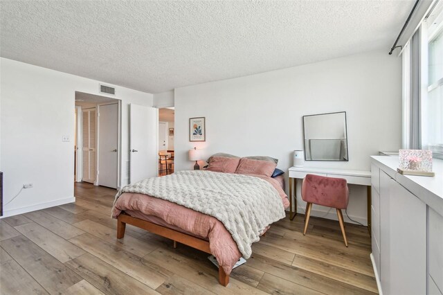 500 Treasure Island Cswy Unit 607, Treasure Island, FL 33706 - bedroom featuring light wood finished floors, a textured ceiling, and a closet