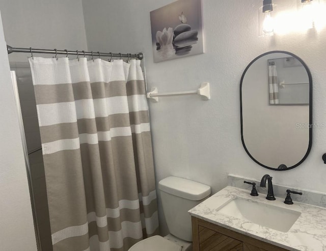 bathroom with toilet, vanity, and a shower with curtain