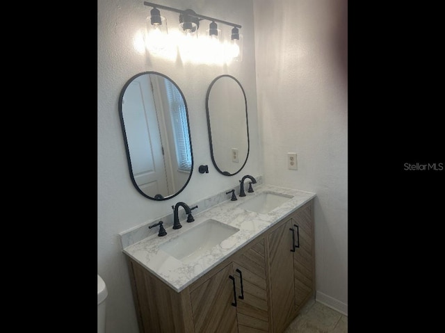 bathroom featuring double vanity and toilet