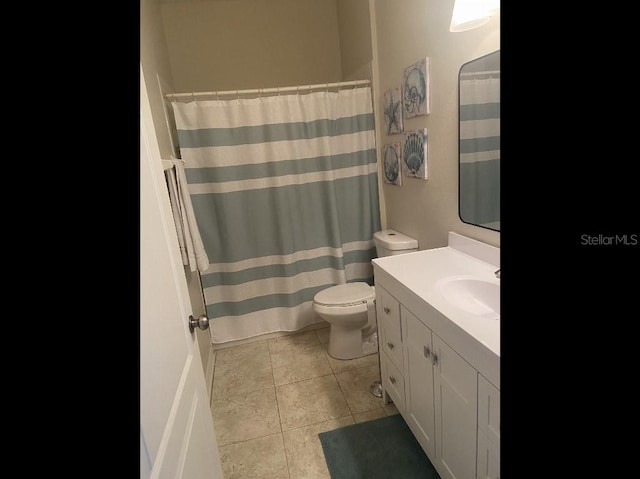 full bathroom featuring toilet, vanity, tile patterned floors, and a shower with shower curtain
