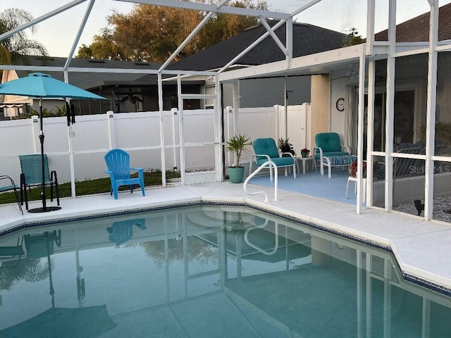 outdoor pool featuring fence, a lanai, and a patio