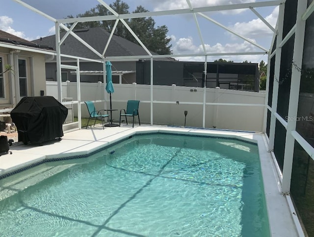 view of pool featuring grilling area, a patio, fence, and glass enclosure