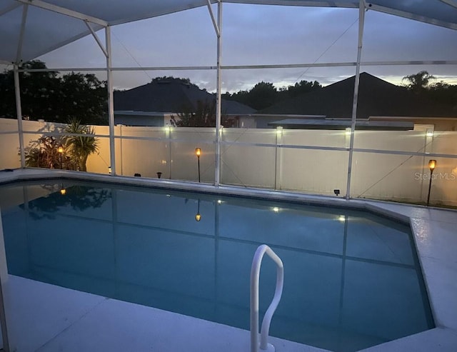 view of pool with a lanai and fence