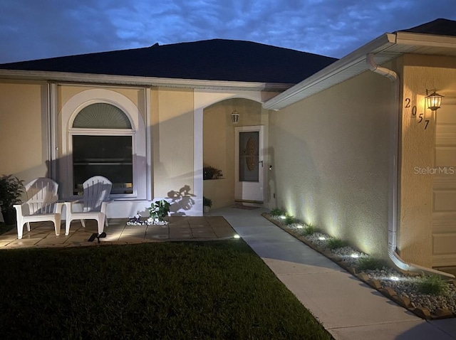 entrance to property featuring stucco siding