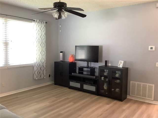 2057 Swift Rd, Oviedo, FL 32766 - living area with wood finished floors, a ceiling fan, and a textured ceiling