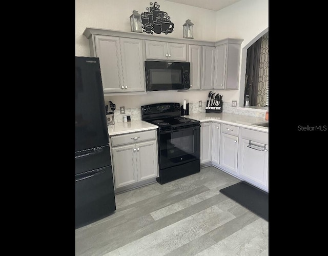 2057 Swift Rd, Oviedo, FL 32766 - kitchen with black appliances, light countertops, and light wood-type flooring