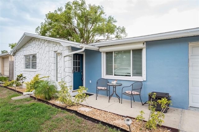 rear view of property with stucco siding and a patio