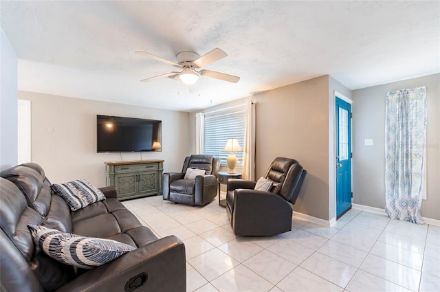 living area featuring ceiling fan, baseboards, and light tile patterned flooring