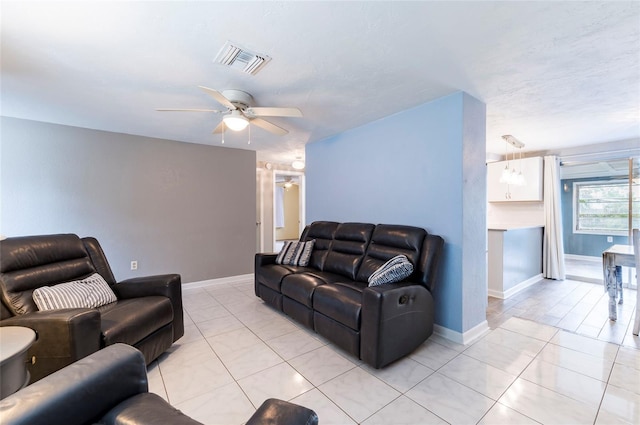 living room featuring a ceiling fan, light tile patterned flooring, and baseboards