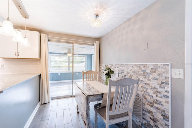dining space with a ceiling fan and baseboards